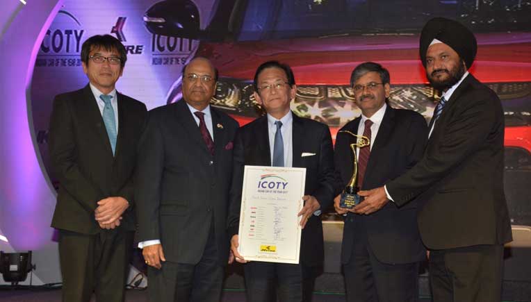 Dr. Raghupati Singhania of JK Tyre & Industries Limited, presenting the Indian Car of the Year Award 2017 to Kenichi Ayukawa and Randhir Singh Kalsi of Maruti Suzuki 